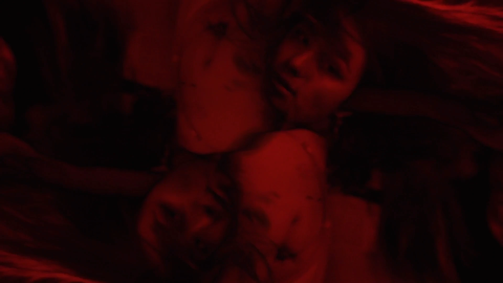 Two figures close in red light, Behind the Concrete Wall