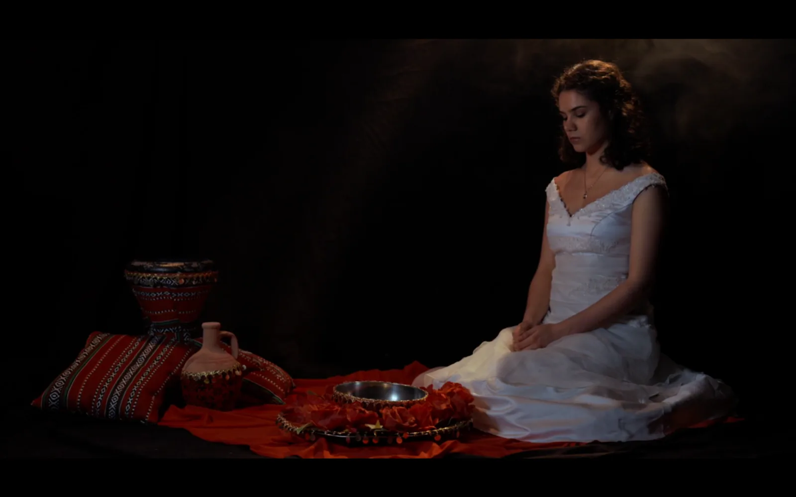 Warm tungsten still from Bride of Stolen, a seated figure by candlelight