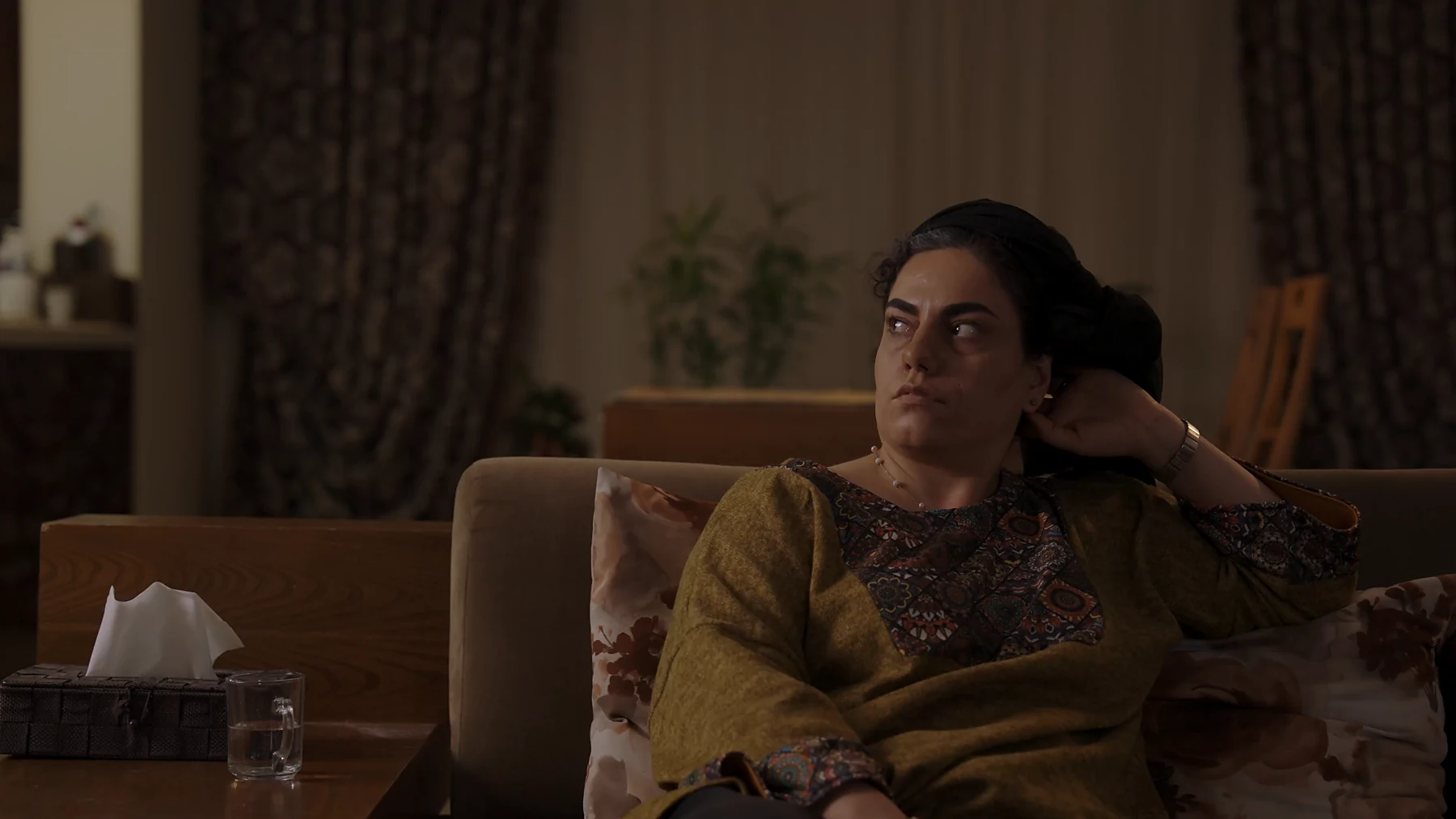 Seated on a sofa in low light, The Transfer